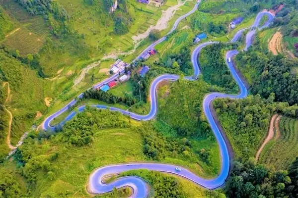 Une vue panoramique du col de Ma Pi Leng, l’un des endroits les plus pittoresques de la boucle de Ha Giang, avec une moto au premier plan.