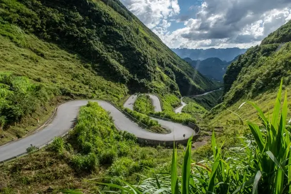Una motocicleta en una carretera estrecha y sinuosa a lo largo del paso Ma Pi Leng, una de las secciones más peligrosas del bucle de Ha Giang.